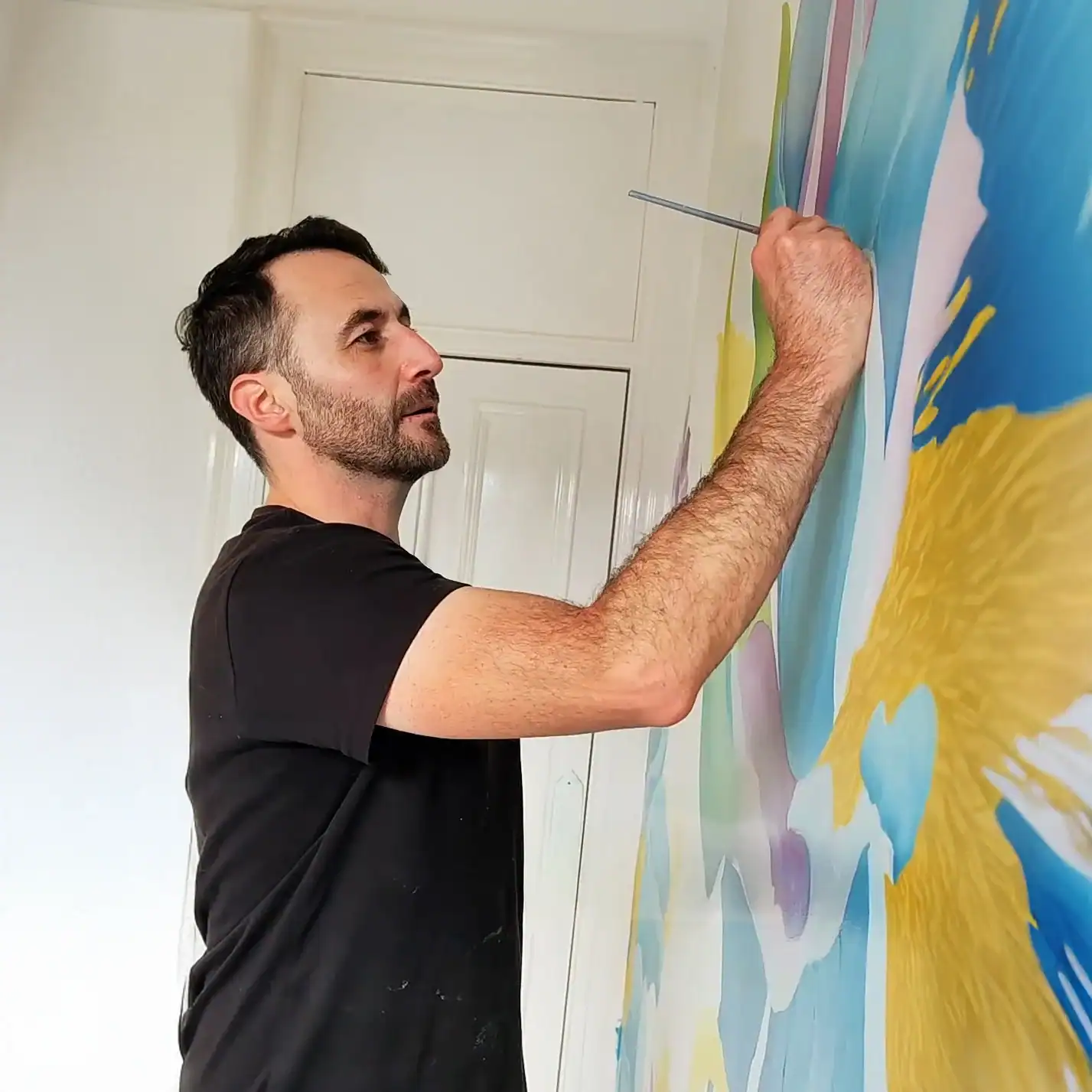 Mural painter in Edinburgh David Jimenez creating a custom wall mural on site