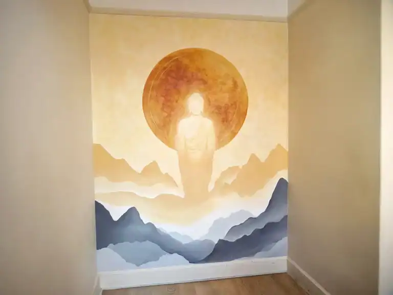 Hand-painted interior wall mural of a Buddha in earth tones for a meditation room